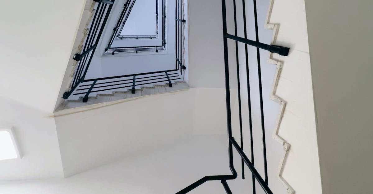 A unique perspective of a modern staircase design with black handrails, emphasizing architectural lines.